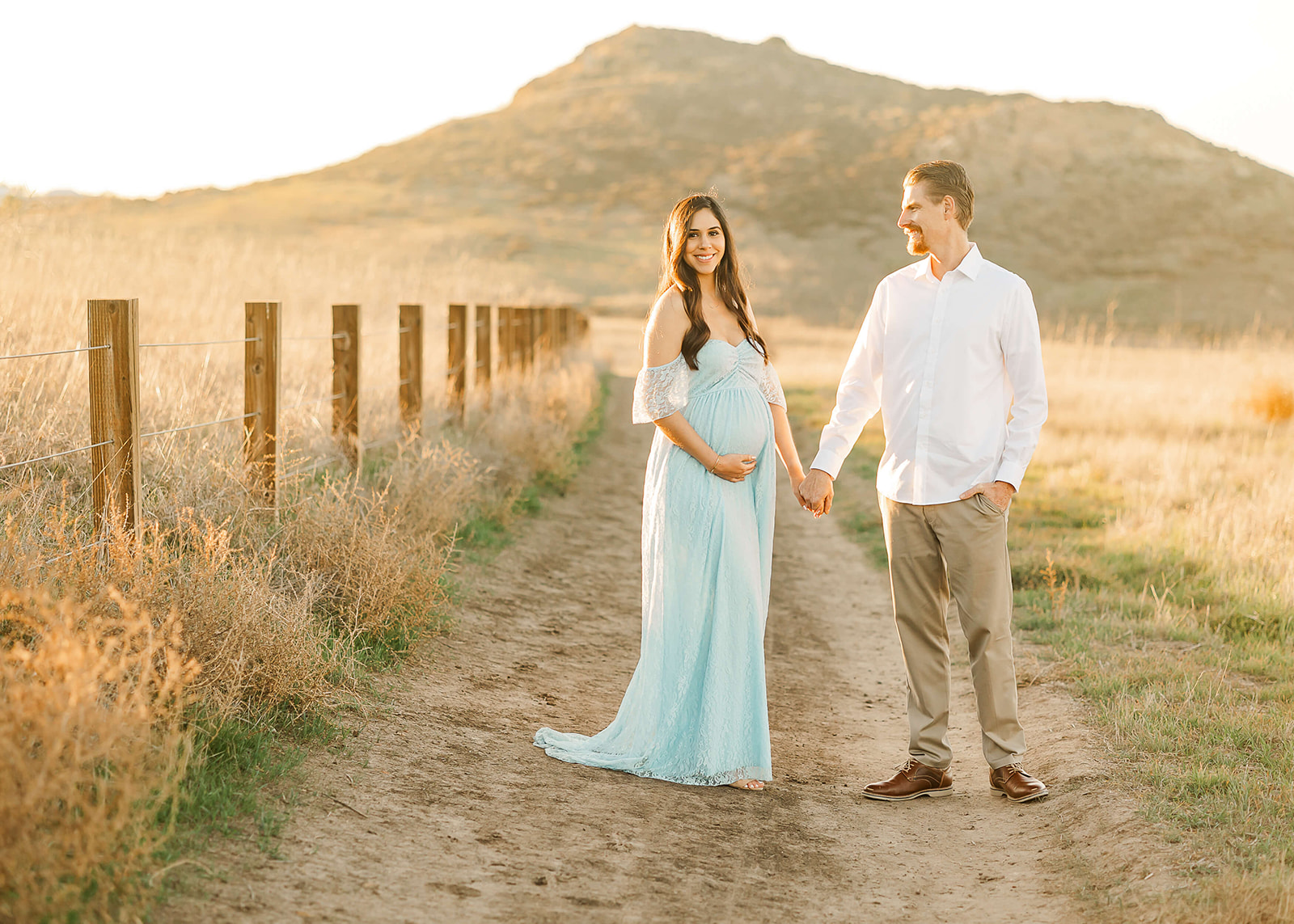 mom to be in blue gown holding her bump and her husbands hand Birthing centers in Orange County