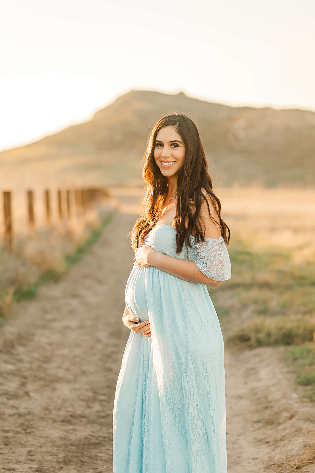 mom to be in blue maternity gown holding her bump Birthing centers in Orange County