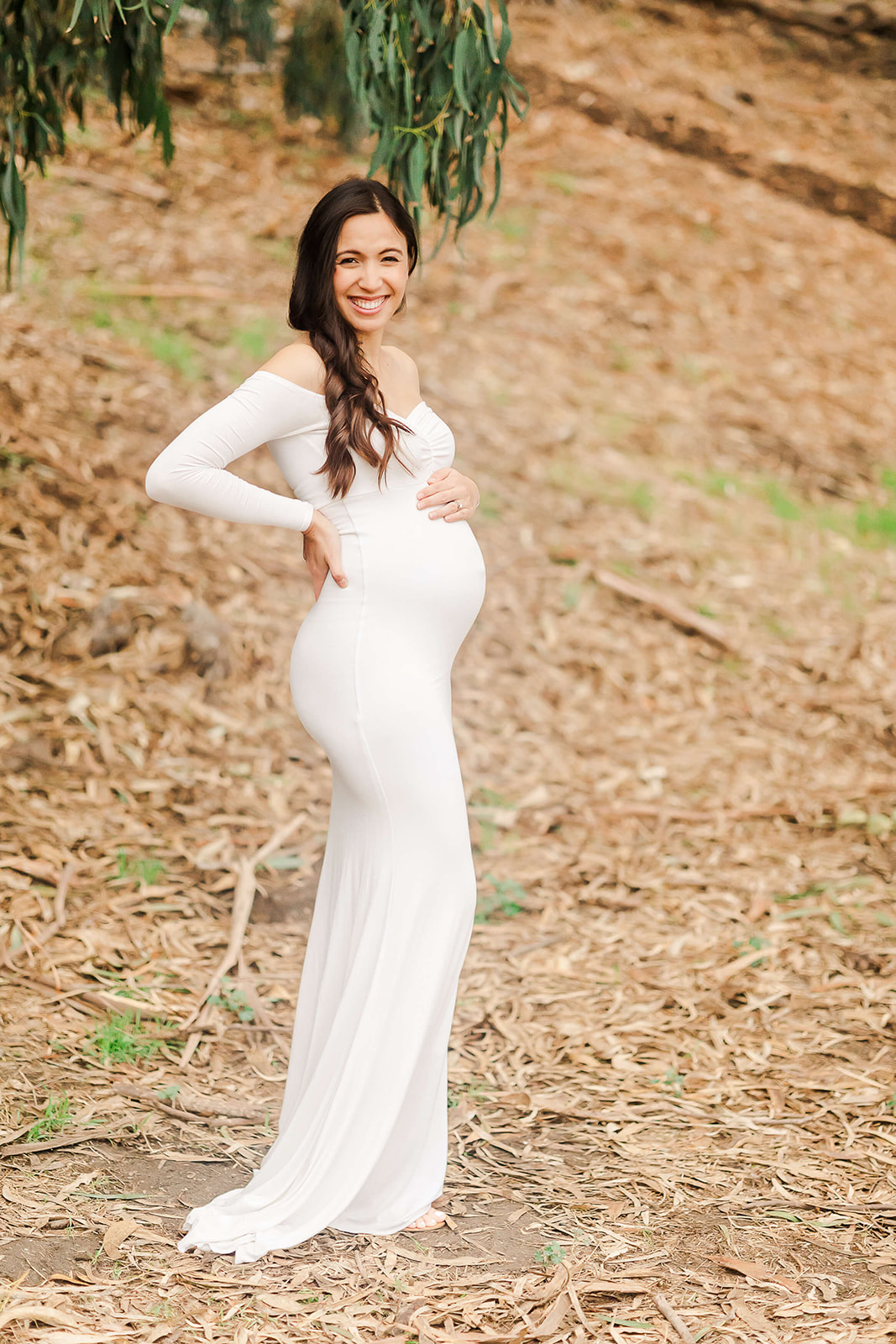 mom to be in white gown holding her bump Orange county midwife