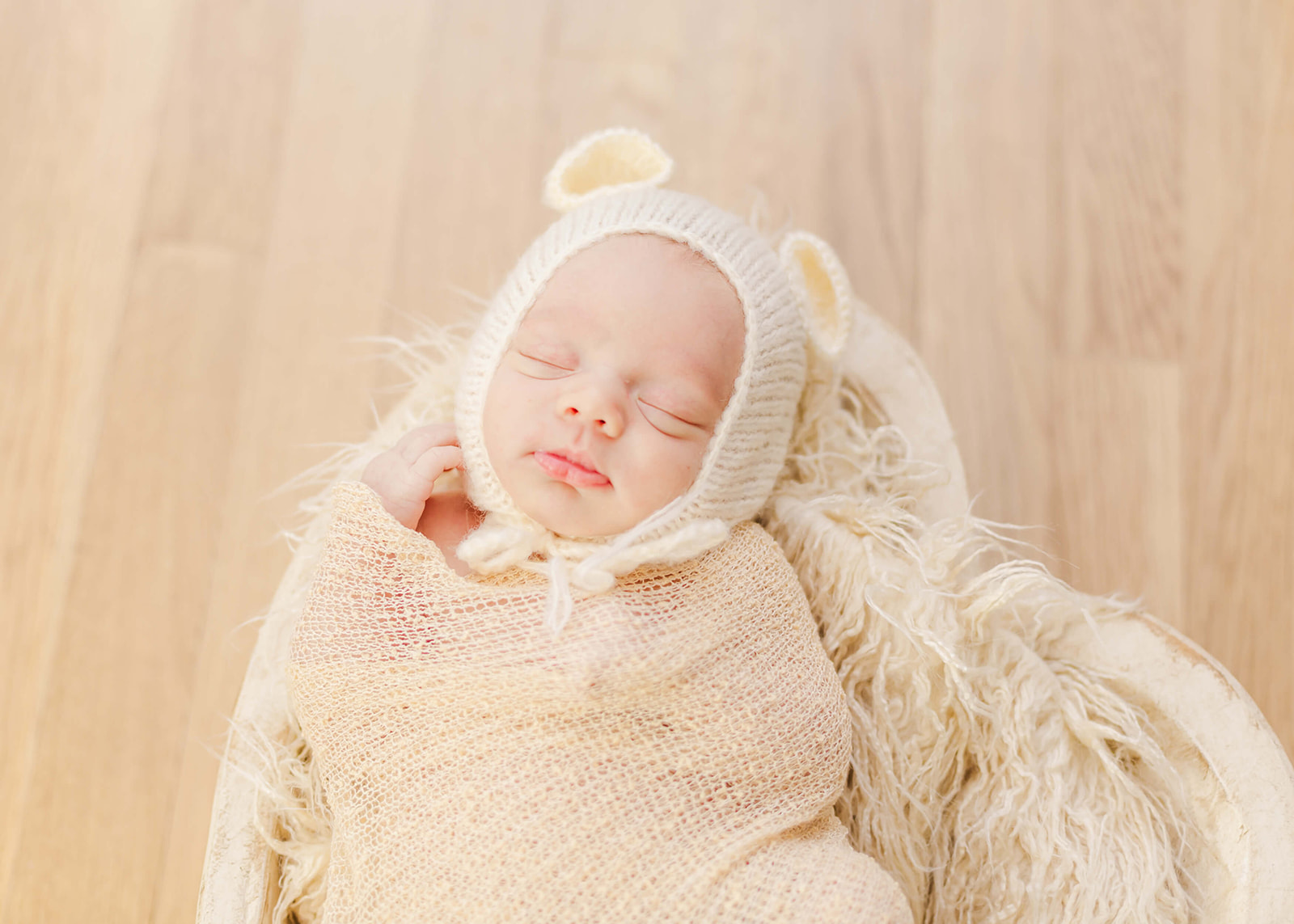 newborn baby with a bear bonnet sleeping
