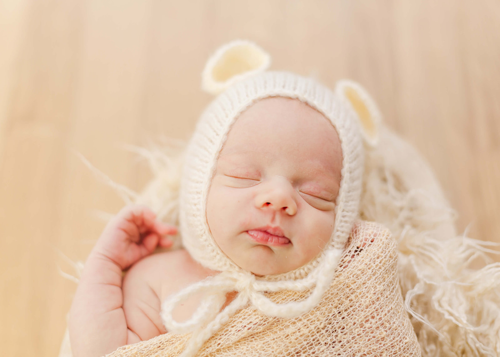 newborn baby sleeping in a basket with a bear bonnet Temecula Pediatricians