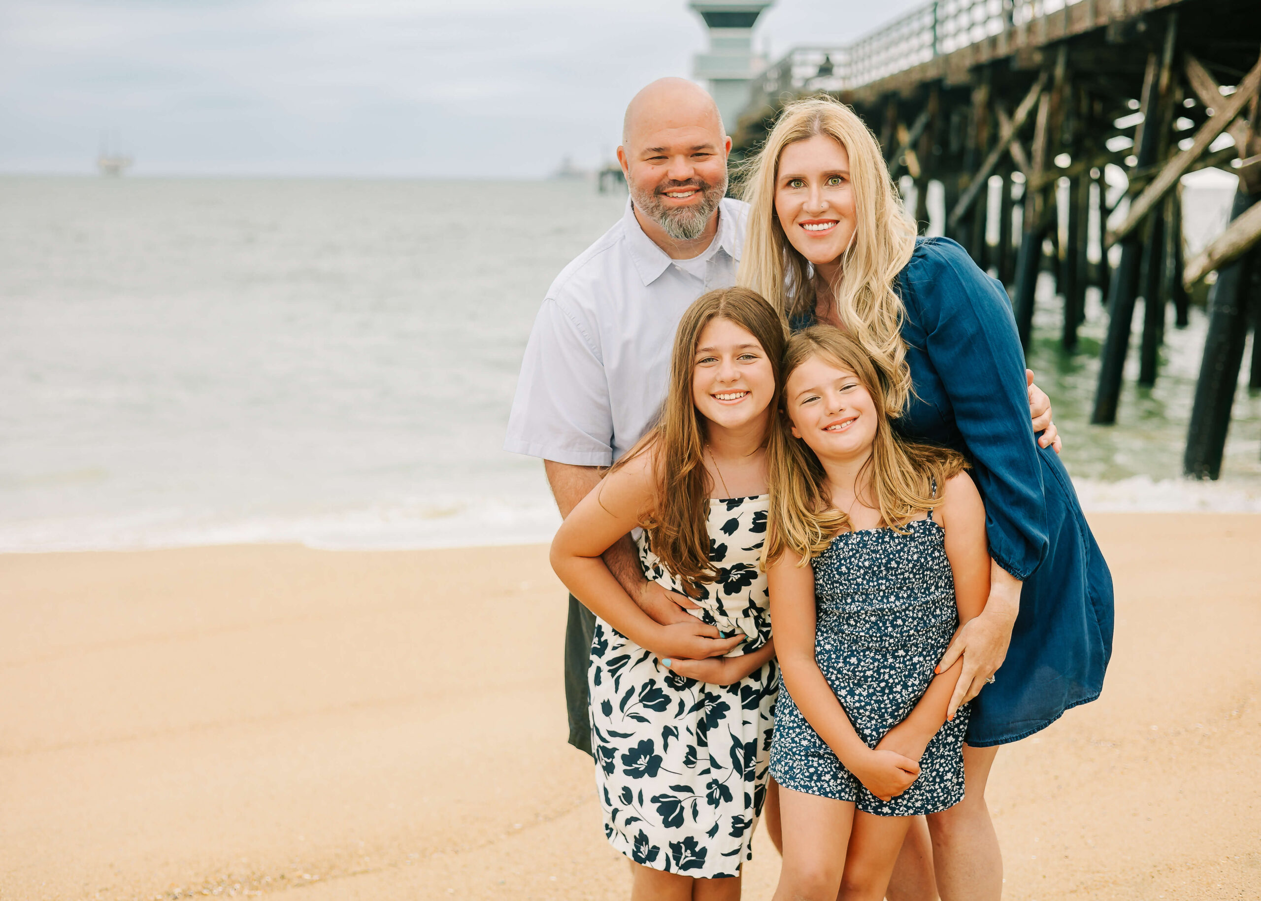 Family snuggled all cozy during their beach family session by Ashley Nicole Photography.