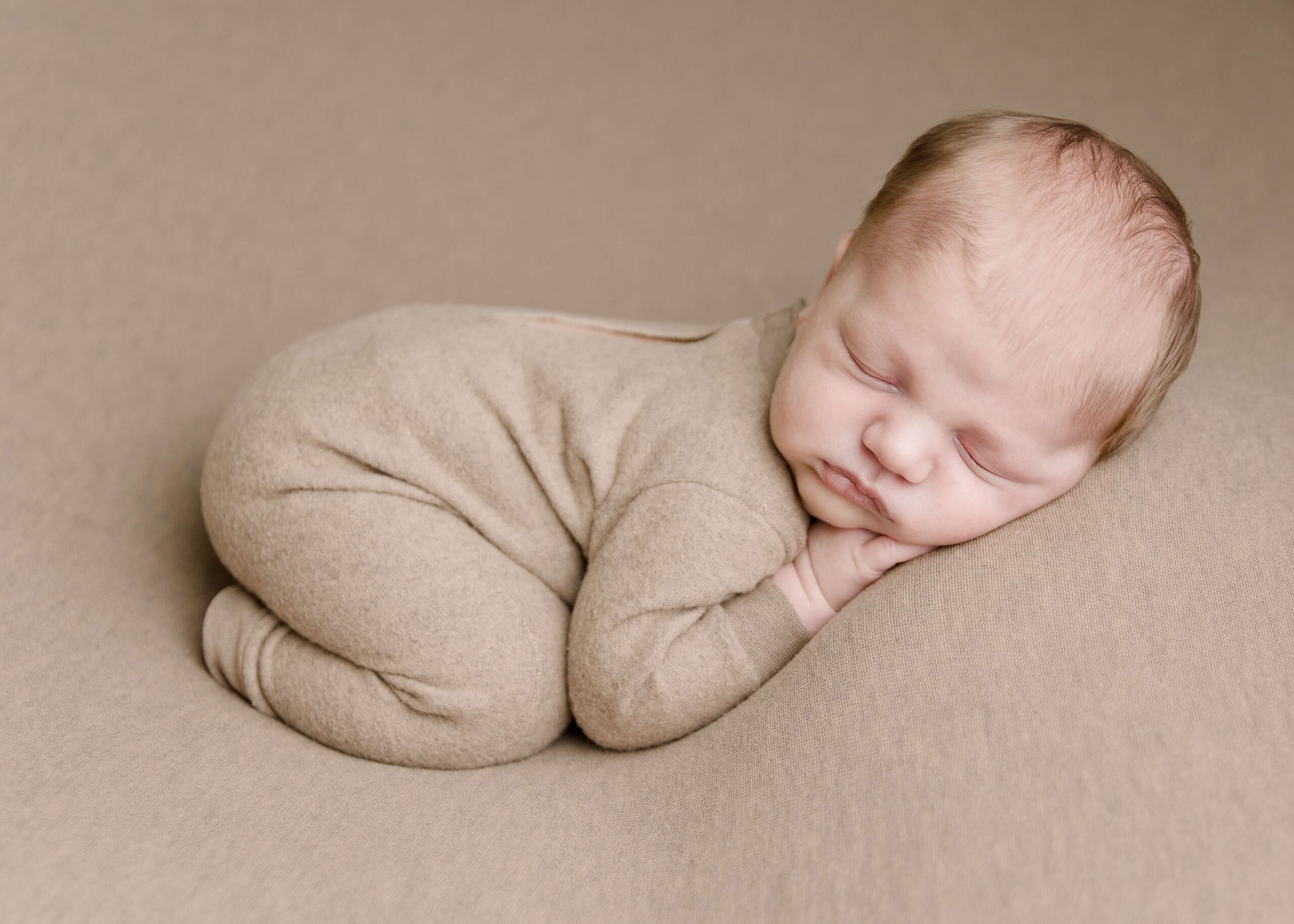 Baby boy posed in studio with bum up pose by Ashley Nicole.