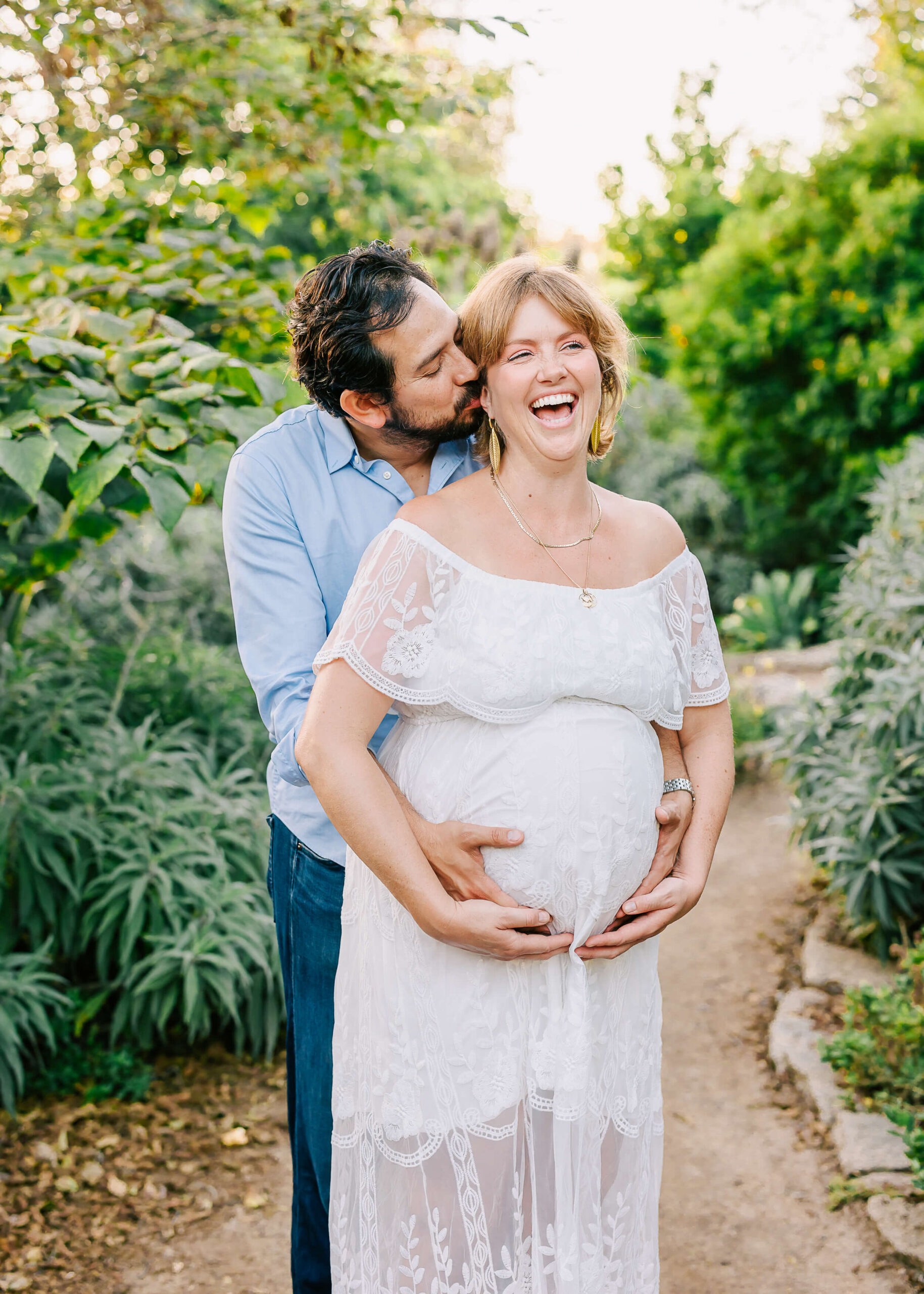 Husband making wife laugh during maternity session.