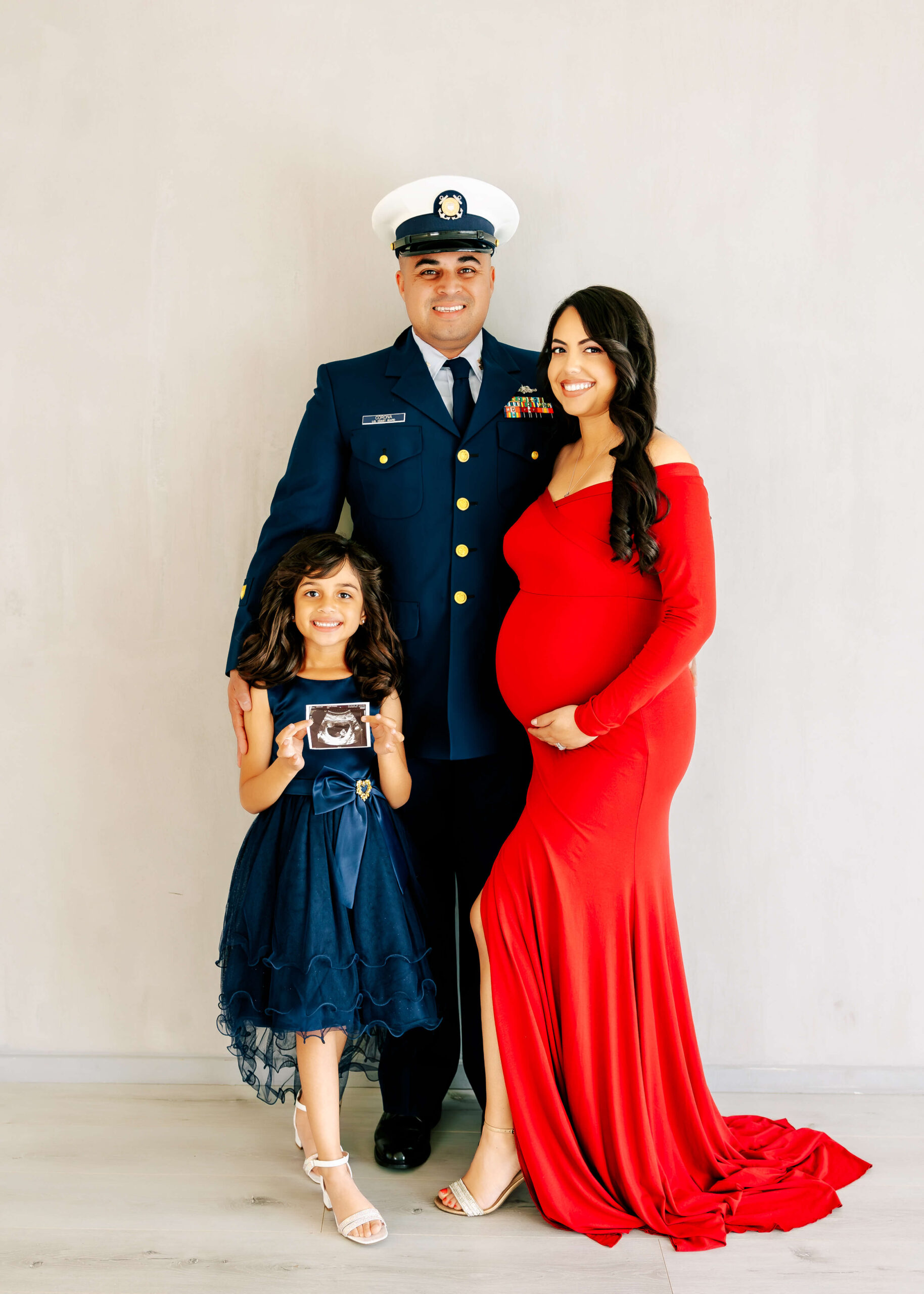 Husband and wife posed with their first child during maternity session in studio by Ashley Nicole in Orange County, Ca.